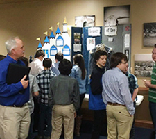 A group of students and adults with History Day exhibits.