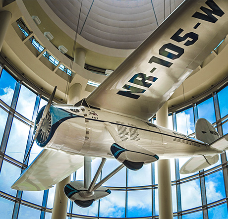 A replica of the Winnie Mae single-engine monoplane suspended above the main hall of the Oklahoma History Center.
