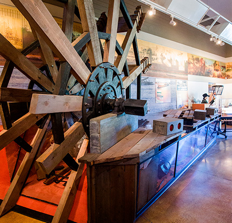 A replica of a paddle wheel attached to a exhibit wall for the Steamboat Heroine.