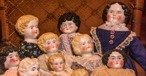 Antique Dolls grouped in a chair.