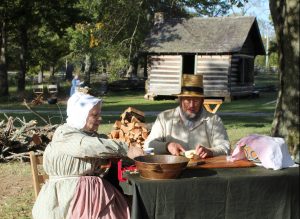 A man and a woman peeling apples in preparation for making apple butter at Hunter's Home.