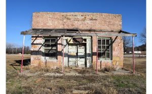 Broken awning, rustic doors and stone structure of the Abe Lincoln Trading company building.
