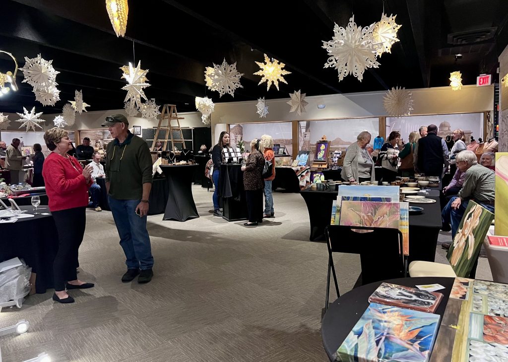 Large snowflakes hang above tables selling artwork at the Museum of the Western Prairie Holiday Sale.