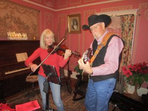Jim Garling and Suzanne Wooley playing fiddle and guitar at the Drummond Home Christmas event.