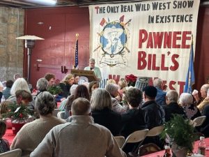 A group of Pawnee Bill members at the Holiday member meal. They are seated at tables and listening to a speaker.