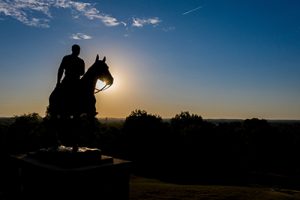 Will Rogers riding his horse Soapsuds sculpture at sunset.
