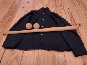 An historic blazer, two antique baseballs, and a baseball bat.