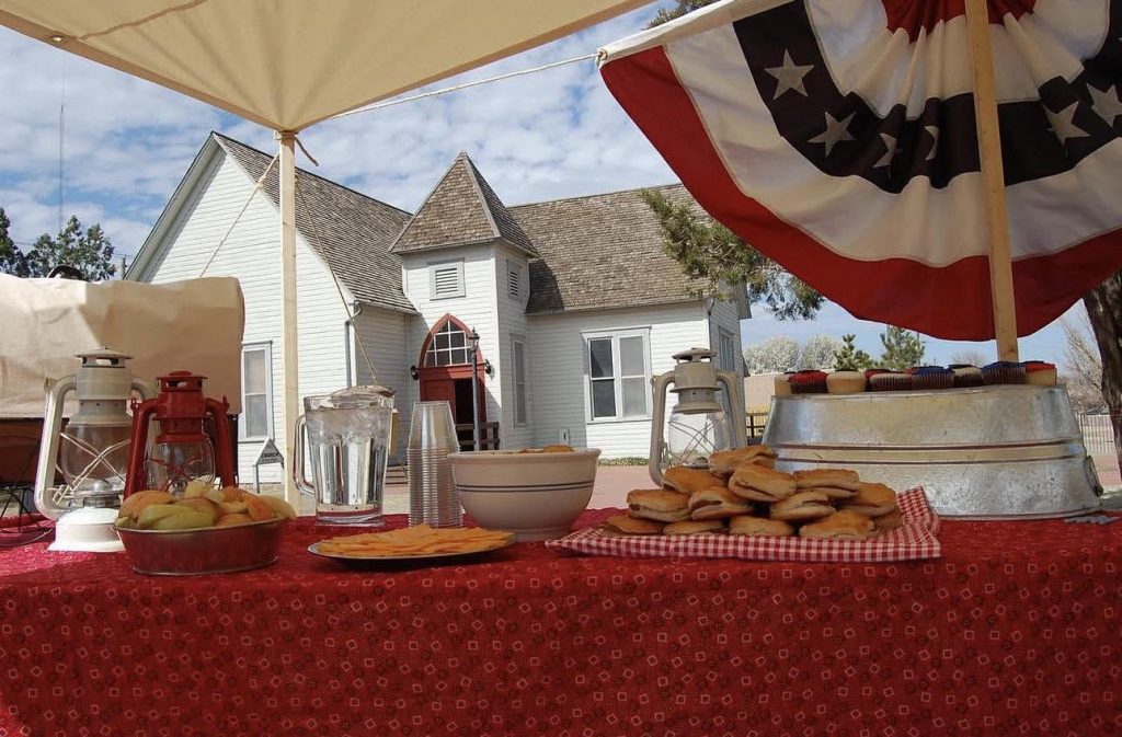 A table full of refreshments for a 4th of July celebration. A patriotic bunting hangs over the table.