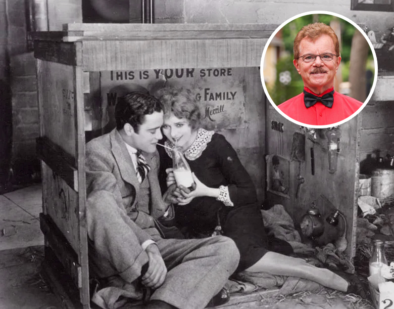 Silent film star Mary Pickford huddles in a wooden crate with her beau, and a portrait of organist Clark Wilson