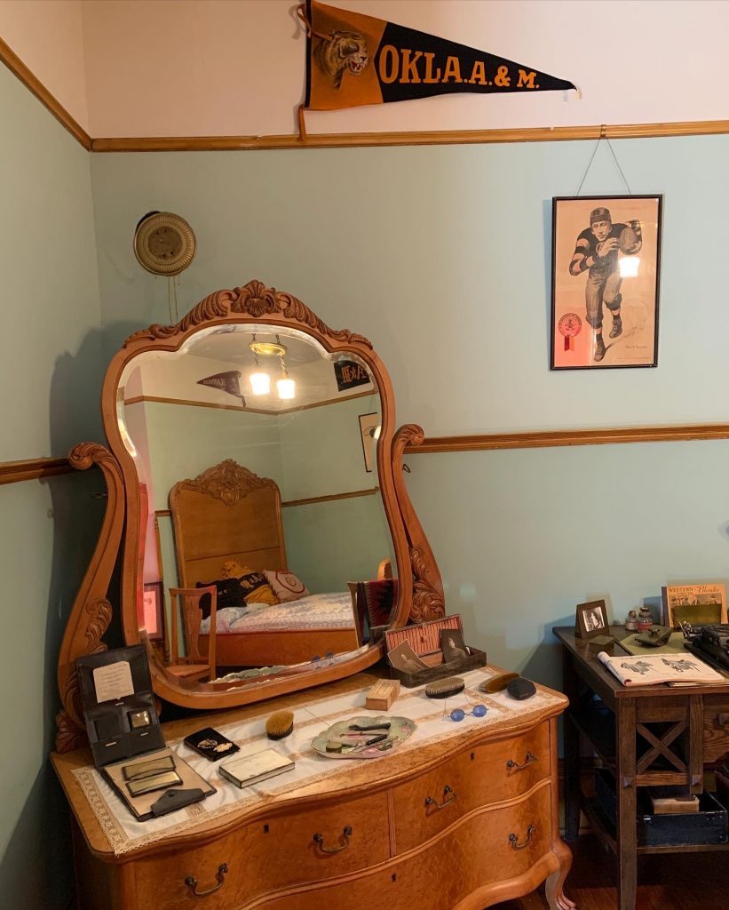 Drummond Home bedroom, with antique football pennants and illustrations on the wall.