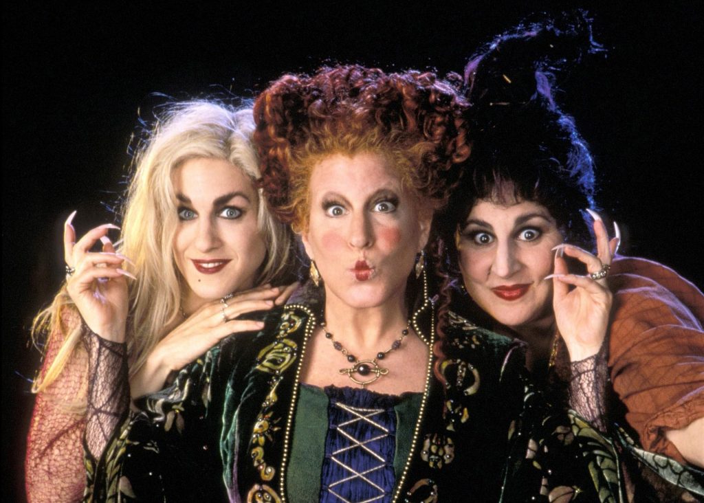 Three women dressed as witches with elaborate hairdos.
