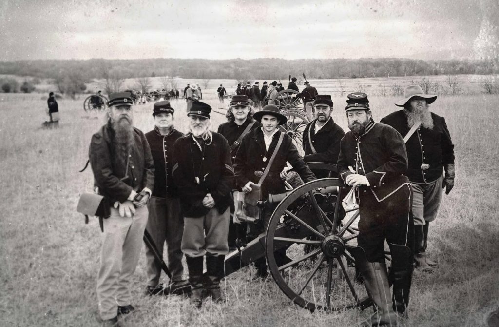 Living historians dressed in Union uniforms gathered around a Howitzer cannon. The modern image has been altered to appear as a period photograph.