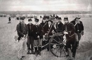 Living historians dressed in Union uniforms gathered around a Howitzer cannon. The modern image has been altered to appear as a period photograph.