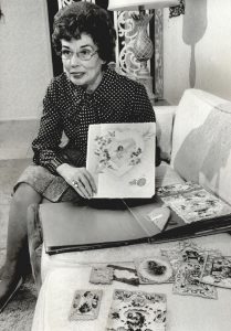 A woman holds an example of a vintage valentine card.