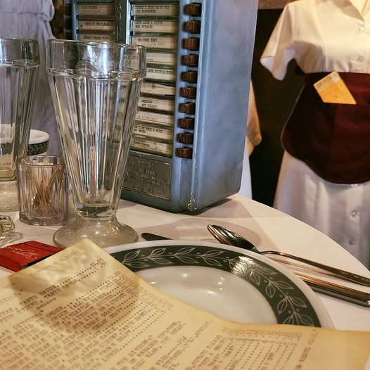 A malt glass, diner plate, menu, and fifties-style waitress outfit.