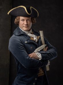 Kurt Smith dressed in Colonial era tri-cornered hat and coat. He is holding a quill and a copy of the Declaration of Independence.