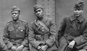 Black World War I soldiers seated, wearing Croix de Guerre medals earned from the French government.