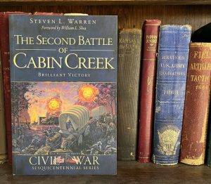 The bookcover of "The Second Battle of Cabin Creek" depicting mule-led covered wagons escaping a Civil War battlefield.