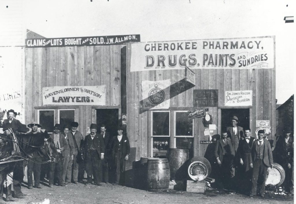 A pharmacy in Enid, Oklahoma Territory with a board and batten construction and a hand-painted sign.