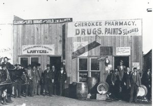 A pharmacy in Enid, Oklahoma Territory with a board and batten construction and a hand-painted sign.