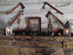 A framed picture, lit lanterns, and toy soldiers decorate a mantel in the soldier's palisade room. Hatchets adorn the wall above the fireplace.