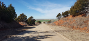 A stretch of concrete highway with red dirt embankments to either side.