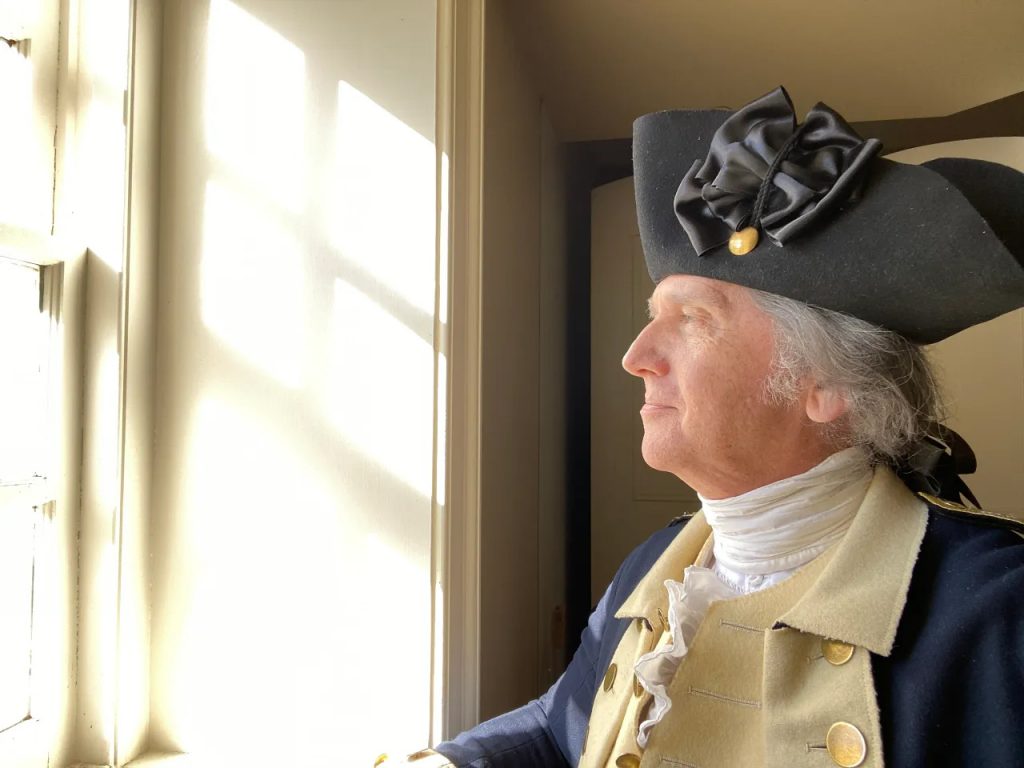 A man dressed in reenactor's clothing, portraying George Washington.