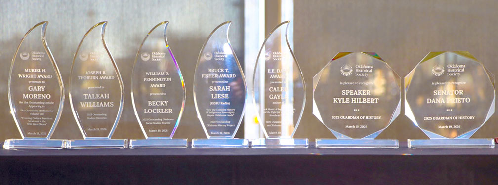 A row of seven acrylic awards featuring the names of awardees.