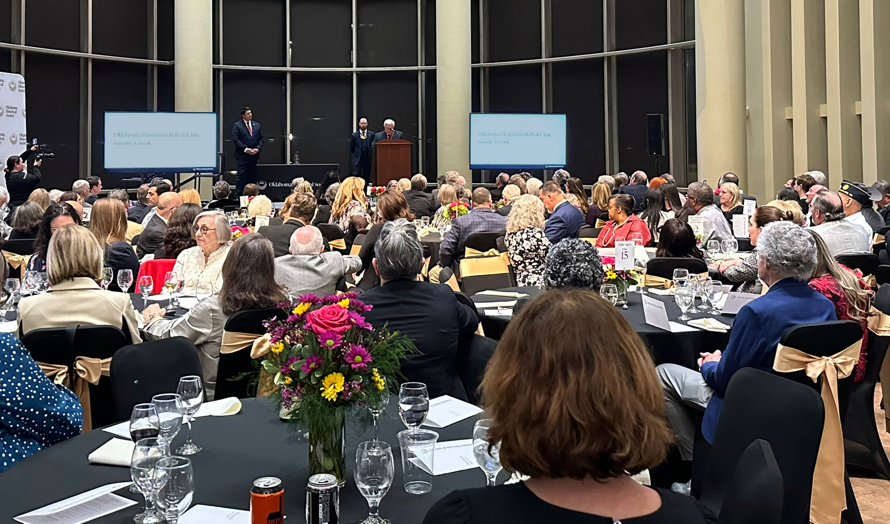 Banquet attendees seated at round tables listen as Dr. Tim Zwink is inducted into the Oklahoma Historians Hall of Fame.