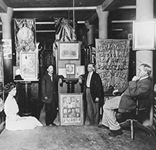 Historical image of three OHS staff among numerous framed images and banners
