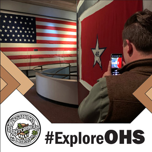 A man takes a selfie inside an exhibit of flags