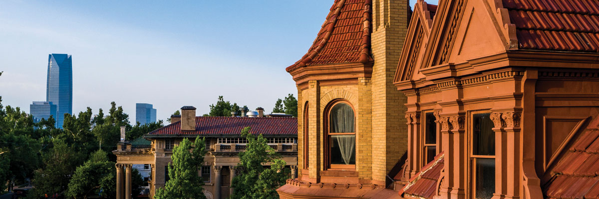 Close-up of the exteror of the Henry and Anna Overholser Mansion with skyscrapers visible in the background