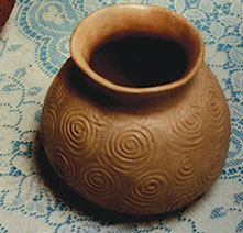A small clay pot with designs in concentric circles