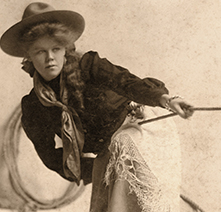 Cowgirl Lucille Mulhall leans as she pulls on a rope