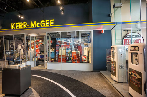 Gas pumps and a yellow lighted Kerr McGee sign