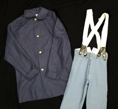 A man's dark blue button-down long-sleeved shirt and pants with white suspenders.