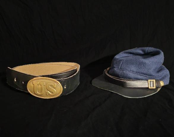 A black belt with a large, gold buckle with the letters U S and a blue military hat with a short brim.