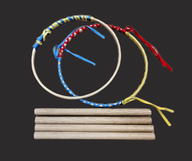 Two hoop wrapped with colorful ribbons next to four rounded wooden sticks.