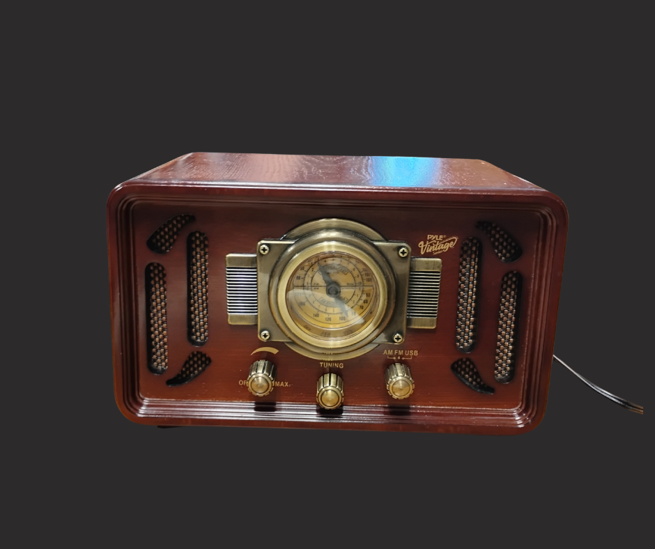 A small, wooden, vintage-style radio with knobs and a dial.