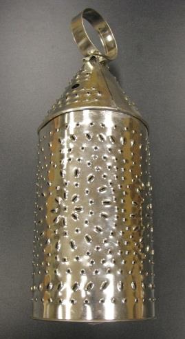 A metal lantern with small holes in a sunburst pattern and a metal loop on top for carrying.