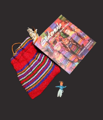 A small woven bag with a booklet and a tiny handmade doll.