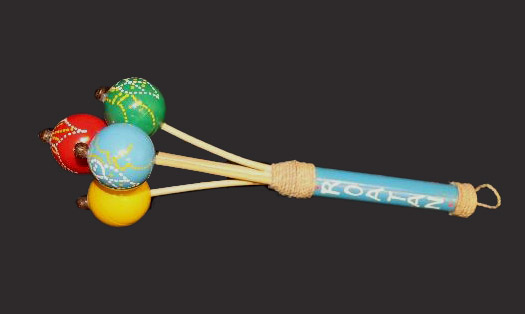Four round, colored rattles attached to a wooden handle.