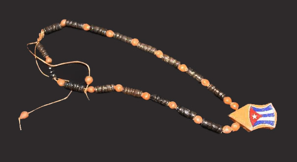 A wooden beaded necklace includes a wooden shape painted like the Cuban flag.