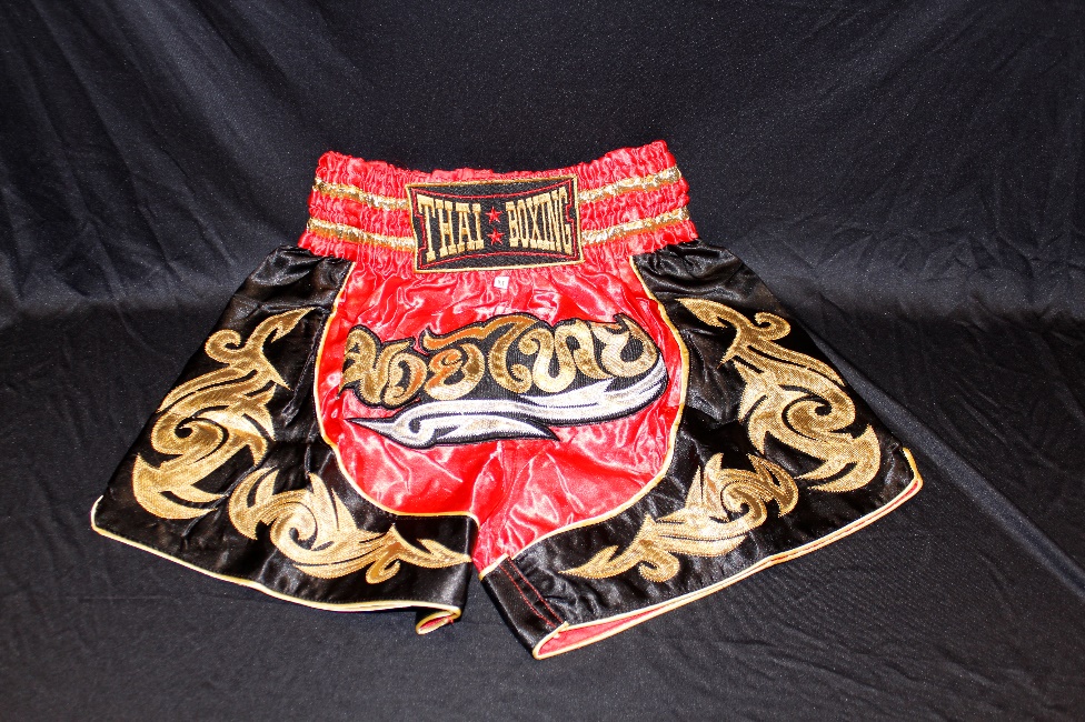 Shorts with gold designs and the text Thai Boxing on the waistband.