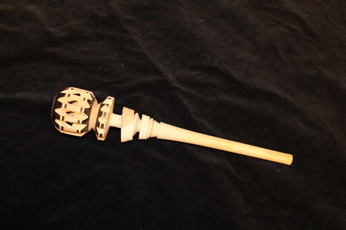 A wooden implement with a notched, ball-shaped top and long handle.
