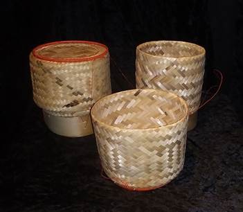 Woven wicker cylindrical containers with lids.