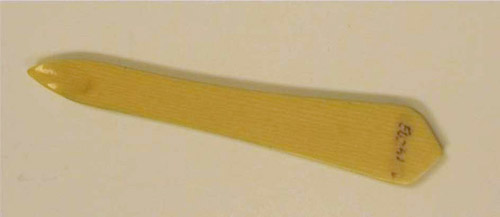 A small wooden tool with a tip that curves into a rounded point.