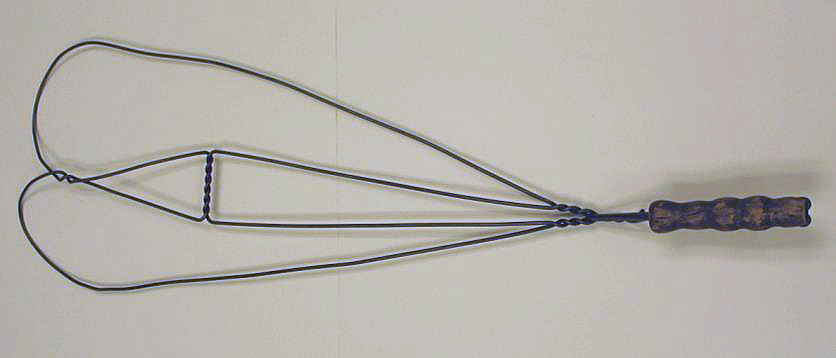 A metal tool with wire loops on one end and a wooden handle on the other.