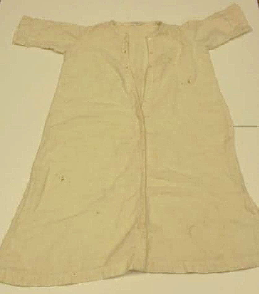 A simple white gown with buttons at the neck.