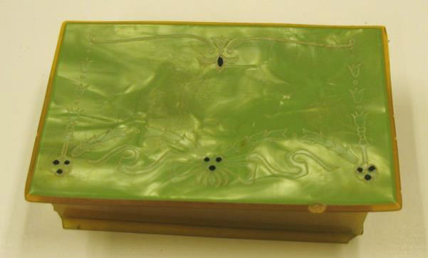 A small box with a swirling green celluloid lid.